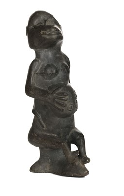 Lot 73 - African Carving. A 20th century hardstone fertility figure and shield
